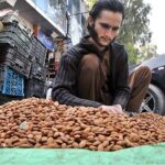 A vendor busy in cleaning almond at Aabpara