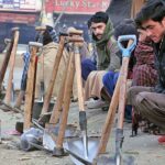 Labourers alongwith their tools sitting on roadside waiting for clients to be hired for work during morning time at Khanna Pul