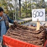 A vendor arranging and displaying fig (Anjeer) to attract customers at Stadium Road.