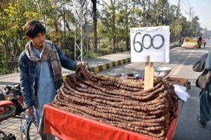 A vendor arranging and displaying fig (Anjeer) to attract customers at Stadium Road.