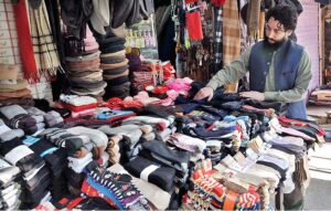 A vendor arranging and displaying socks to attract the customers at Aabpara