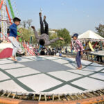 Children enjoying jump on trampoline on the eve of Christmas celebrations at G-7 area.