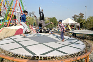 Children enjoying jump on trampoline on the eve of Christmas celebrations at G-7 area.