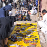 People purchasing second hand shoes at vendors’ roadside setup near Aabpara market