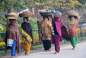 Women vendors on the way loaded with bangles on their head to deliver at Bangles market