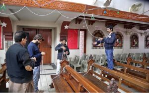 Girls decorating Christmas tree at St. Xavier Catholic Church in connection with Christmas celebration.