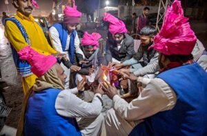 Traditional drummers sitting around fire to keep themselves warm due to cold weather at Faizabad.