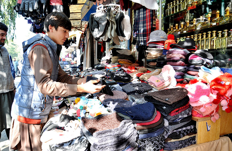 People purchasing second hand shoes at vendors’ roadside setup near Aabpara market