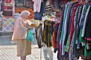 Woman selecting and purchasing warm clothes at Weekly Bazaar Peshawar Mor