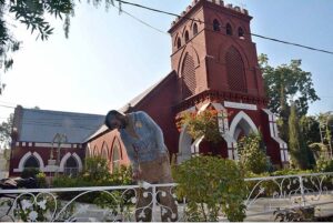 A laborer busy coloring outside grill of church in connection with upcoming Christmas