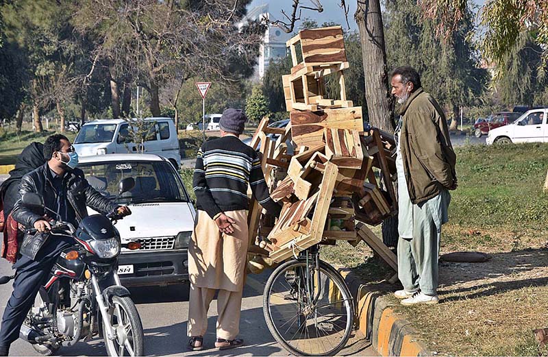 A vendor selling wooden items for home use on his bicycle in G-8, Federal Capital