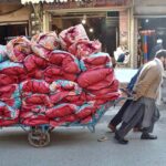 Laborers carrying quilts on his handcart for stitching in a local market at Dabgari area.