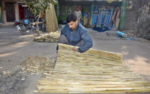  A worker preparing traditional bamboo chick blinds at his workplace on the roadside. 