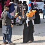 Woman selecting and purchasing warm clothes at Weekly Bazaar Peshawar Mor
