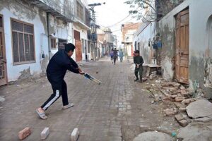 A group of youngsters playing cricket in the street