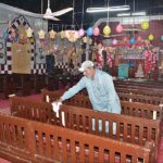 A laborer busy coloring outside grill of church in connection with upcoming Christmas