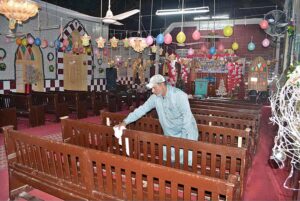 A laborer busy coloring outside grill of church in connection with upcoming Christmas