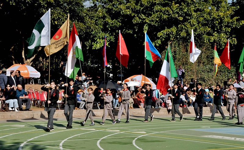 Students holding flags of different countries express solidarity with the children and people of Palestine during the annual sports day meet at the Preparatory School
