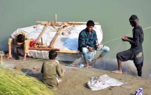 Fisherman busy in preparing the net for catching fishes at water canal. 