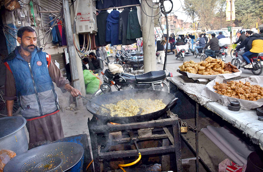 A vendor prepares Pakora for customers as per increased demand in winter.