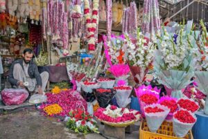 A vendor busy making garlands in his shop at Bani Chowk