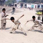 Gypsy children playing traditional game (Gilli danda) at Tando Yousuf.