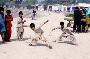 Gypsy children playing traditional game (Gilli danda) at Tando Yousuf.  