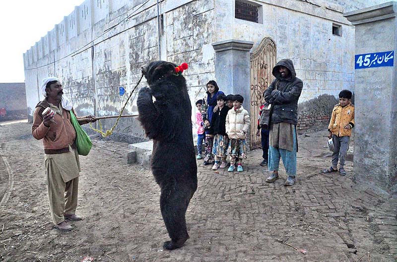 A juggler showing bear dance with his bear in the street