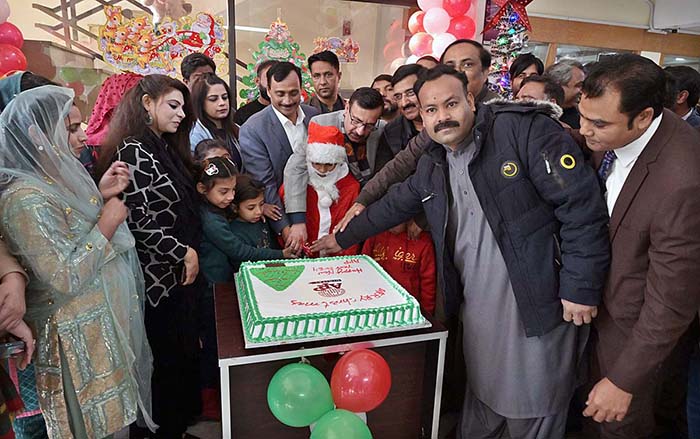 Managing Director Associated Press of Pakistan, Muhammad Asim Khichi along with Christian employees cutting cake in connection with Christmas celebrations.