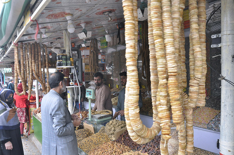 Customers inquiring about dry fruits at a stall in H-9 Weekly Bazar in the federal capital