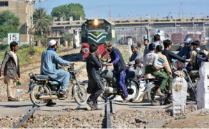 A view of Motorcyclists crossing railway track while train is approaching may cause any mishap and needs attention to the concerned authorities