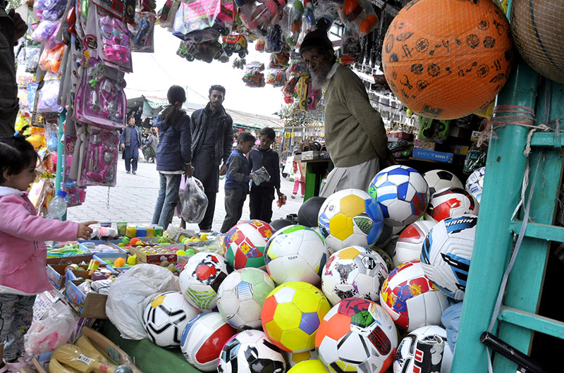 A child is interested to buy ball displayed at a stall at H-9 weekly bazar in federal capital.