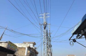 A WAPDA worker busy installing new electric cables on a pylon at Tramri area. 