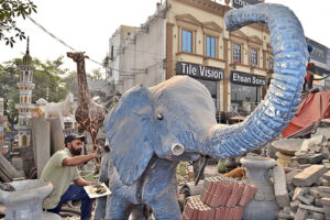 Artist using his artwork skills to restore and finalize an elephant sculpture