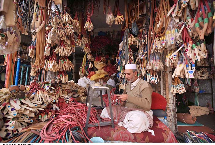 A man is busy in making slingshots for selling purpose at his work place.