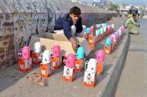 A vendor displaying and selling thermos on footpath to attract customers outside Qasim Bagh