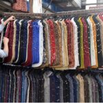 A vendor displaying and selling Waistcoat to attract customers at his roadside setup