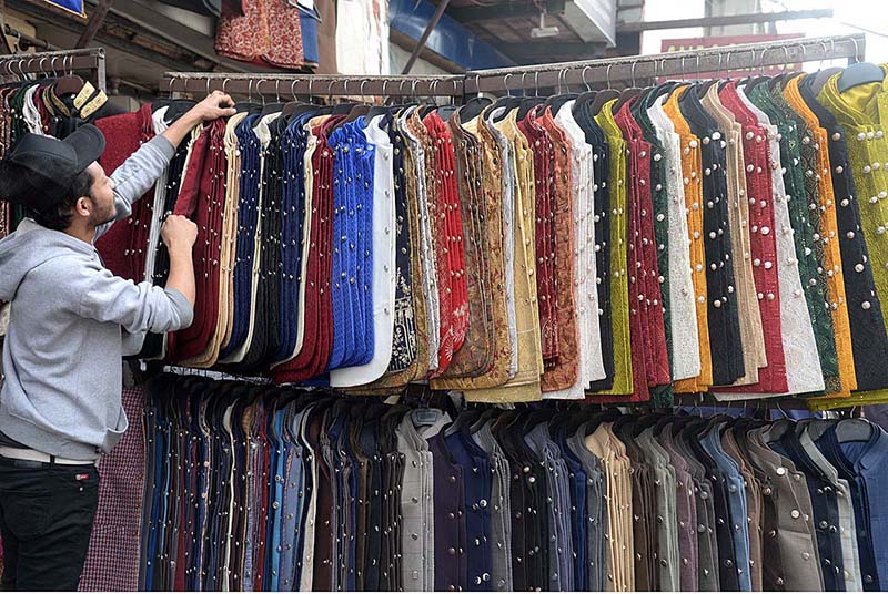 A vendor displaying and selling Waistcoat to attract customers at his roadside setup