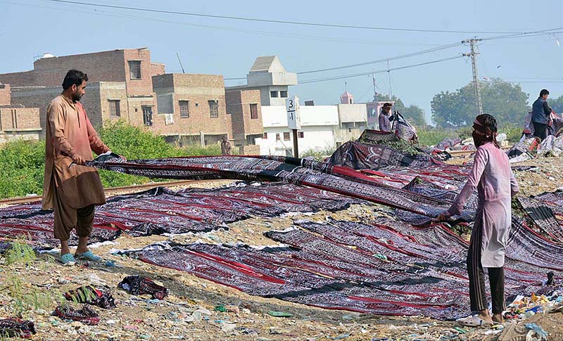 Labourers place Sindhi ajraks in sunlight for drying purpose at Tando Yousuf