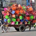 Labourer pulling handcart loaded with children bicycles to be delivered at Iqbal Road