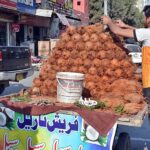 A vendor busy in arranging and displaying coconut on handcart to attract the customers