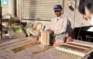 Skilled worker busy making gift baskets at his roadside setup.