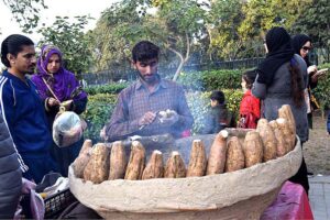 Vendor displaying roasted sweet potatoes to attract the customers