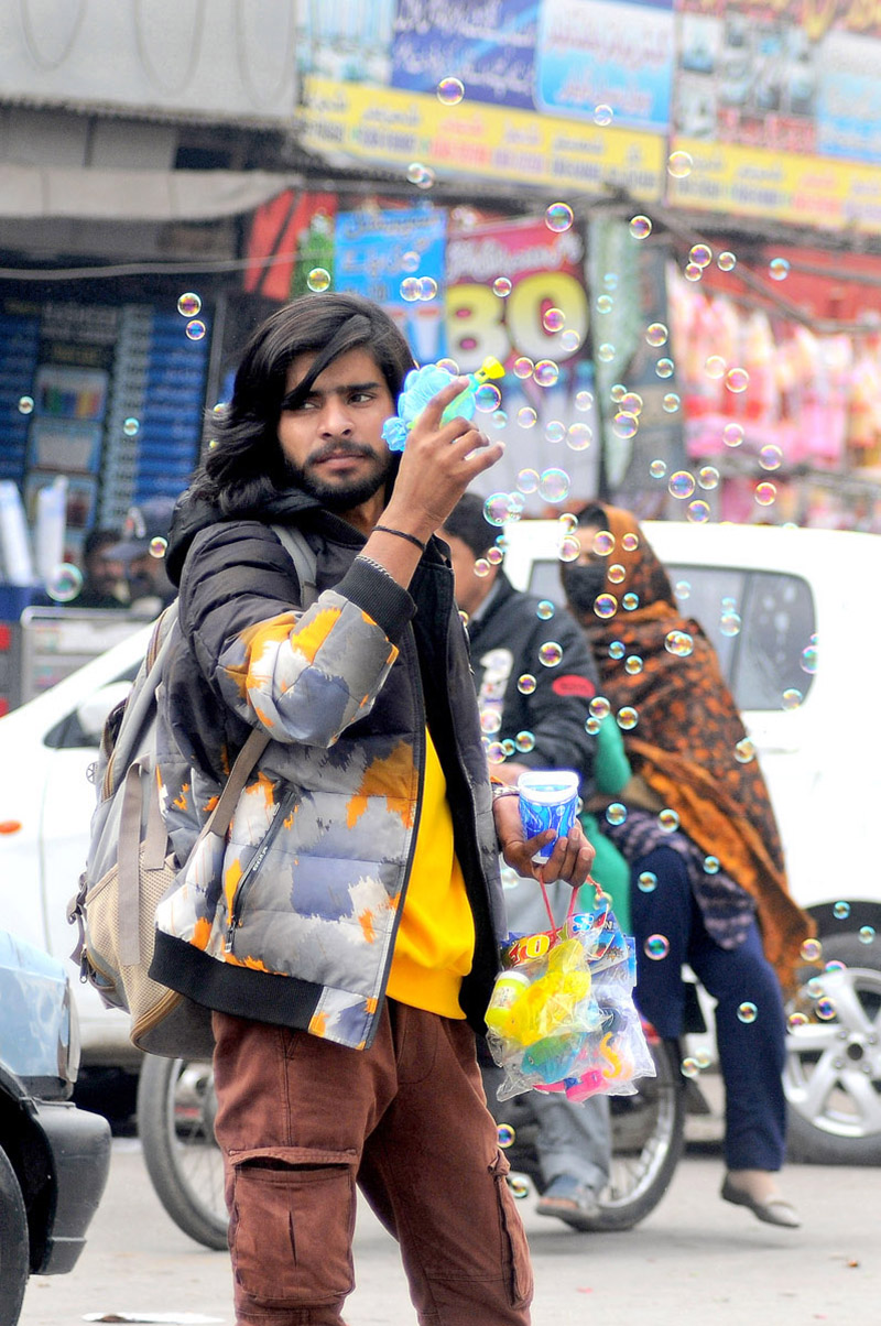 A street vendor displaying and selling bubble guns for kids at Clock Tower Chowk