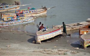 Fishermen paint their boat at Indus River