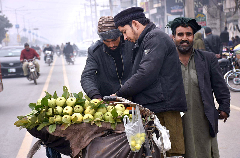 A street vendor selling guavas in middle of the road