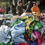 A couple busy in selecting and purchasing second hand warm clothes displayed by vendor at I-9 Weekly Bazaar in Federal Capital.
