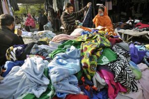A couple busy in selecting and purchasing second hand warm clothes displayed by vendor at I-9 Weekly Bazaar in Federal Capital.