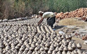 A worker arranging clay-made money boxes for drying purpose at Kumharpara, Jamshoro Road. 