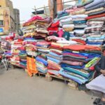 A vendor displaying the blankets to attract the customers on the footpath at bacha khan chowk